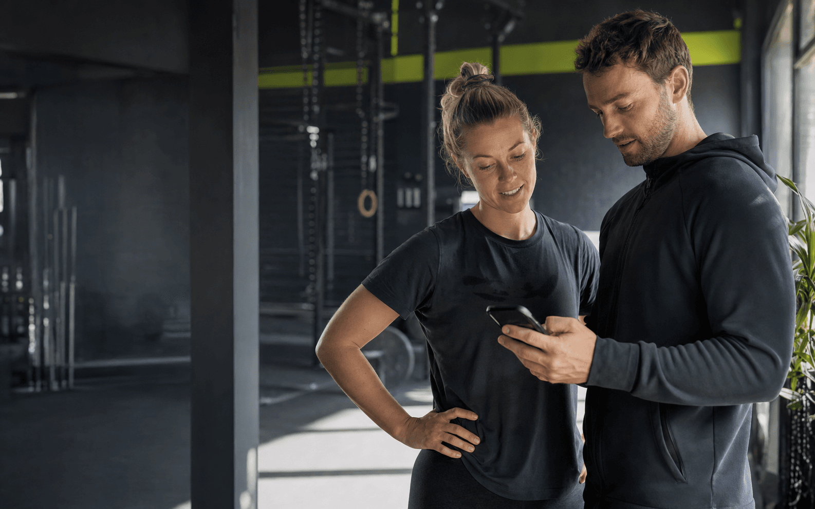 Coach die in een Nederlandse gym met een sporter meekijkt